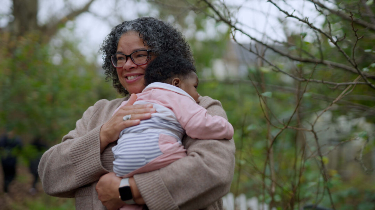 A volunteer holds a young baby as part of the Birth Partner Project.